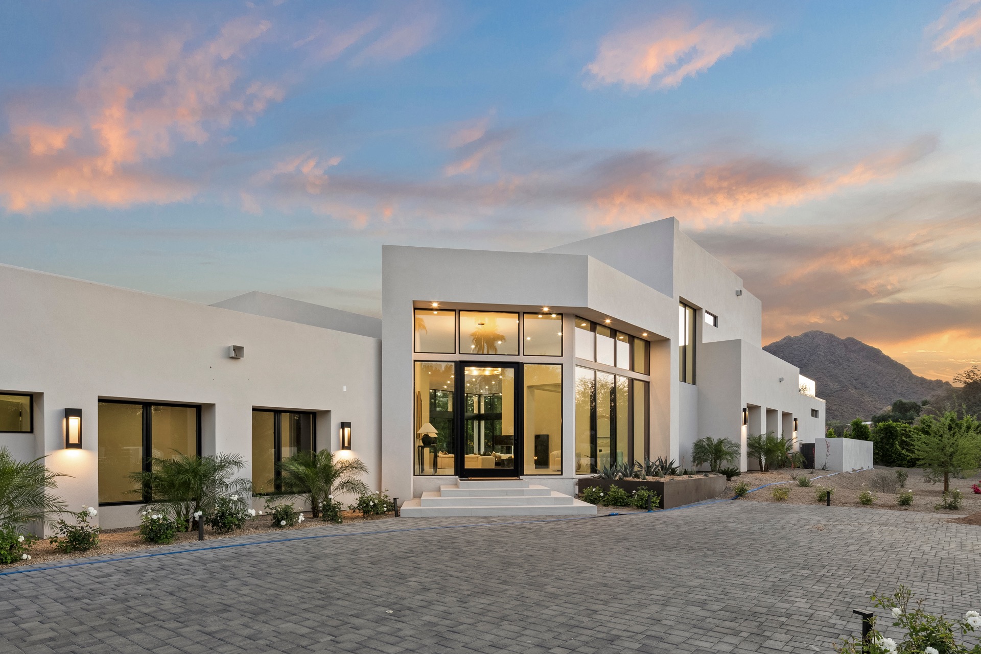 Modern white residence at sunset with desert mountain views